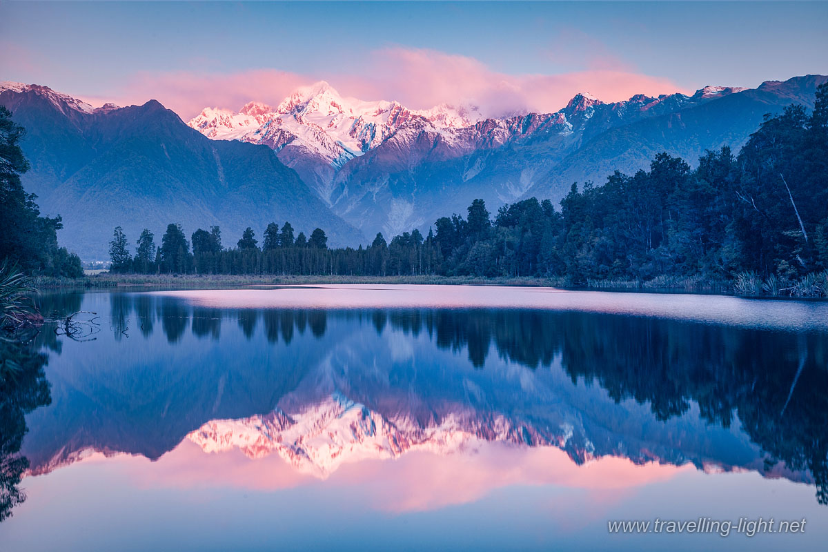 Lake Matheson View
Lake Matheson at sunset with snow covered Mount Tasman and, in the cloud, Aoraki-Mount Cook, New Zealand's highest mountain.
Keywords: Fox Glacier;beauty;blue;destination;green;lake;Lake Matheson;landscape;Aoraki;Mount Cook;Mount Tasman;National Park;mountains;nature;New Zealand;scenery;sky;snow;snow covered;tourist attraction;trees;white;sunset;dusk;evening;clouds;reflection